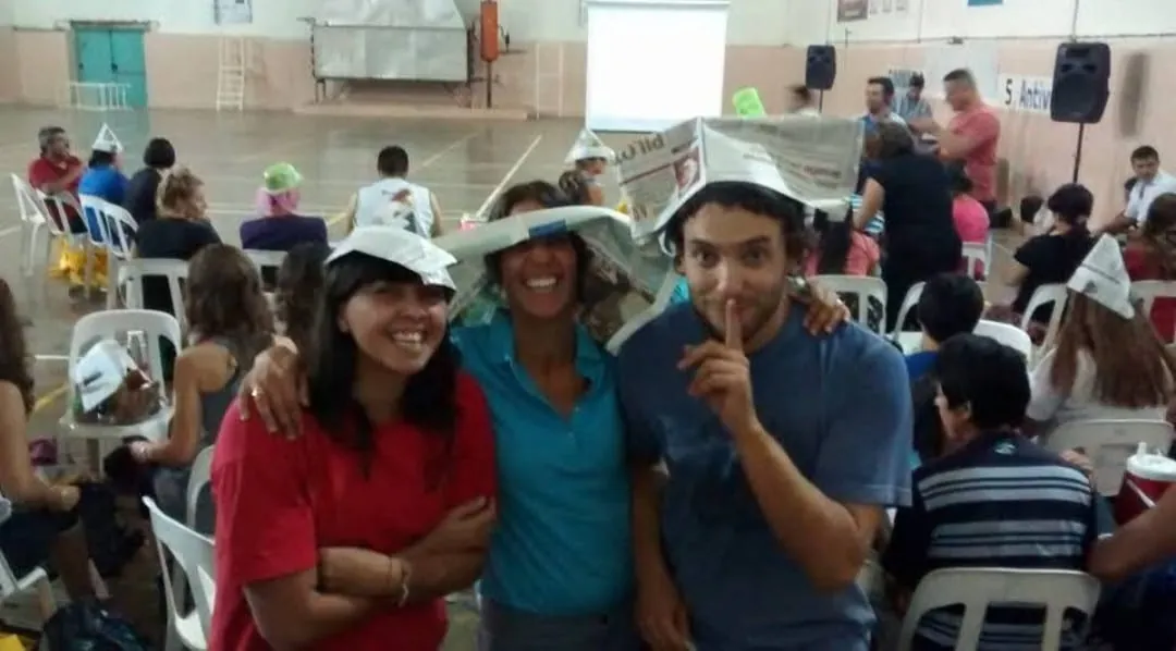 Tres personas con sombreros de papel de diario