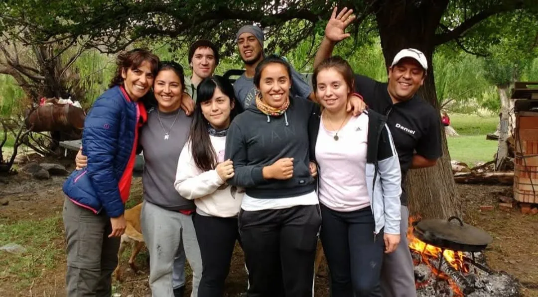 Grupo alrededor del fuego bajo un árbol